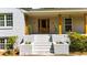 Inviting covered front porch with brick columns, steps, and manicured landscaping for curb appeal at 7300 Wynhill Dr, Sandy Springs, GA 30328