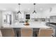Bright kitchen features white cabinets, stainless appliances, quartz countertops, an island with seating, and pendant lighting at 7300 Wynhill Dr, Sandy Springs, GA 30328