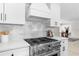 A stainless steel oven and cooktop against a marble backsplash are surrounded by white cabinets and quartz countertops at 7300 Wynhill Dr, Sandy Springs, GA 30328
