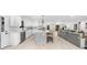 Open kitchen with white cabinets, quartz countertops, stainless appliances, and island seating that flows into the living room at 7300 Wynhill Dr, Sandy Springs, GA 30328