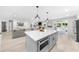 Bright, open kitchen with a gray island and breakfast bar that flows into an open living area at 7300 Wynhill Dr, Sandy Springs, GA 30328