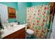 Well-lit bathroom with a vanity, mirror, and shower with a floral curtain, offering a fresh design at 1116 Silverbrooke Dr, Powder Springs, GA 30127