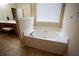 Inviting bathtub with tile flooring and natural light from a window at 1116 Silverbrooke Dr, Powder Springs, GA 30127