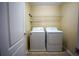 Practical laundry room equipped with a washer, dryer, and shelving for storage at 1116 Silverbrooke Dr, Powder Springs, GA 30127