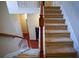 Carpeted staircase with wood railing leads to the upper level of the home at 1116 Silverbrooke Dr, Powder Springs, GA 30127
