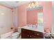 Traditional bathroom with pink walls, shower-tub combo, and vanity, providing a functional and clean space at 127 Marlow Dr, Woodstock, GA 30188