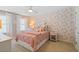 Cozy bedroom with floral wallpaper, plush bedding, and soft, diffused lighting creating a peaceful retreat at 127 Marlow Dr, Woodstock, GA 30188