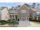 Beautiful two-story brick home featuring a welcoming front porch, manicured landscaping, and a two-car garage at 127 Marlow Dr, Woodstock, GA 30188