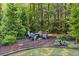 Secluded backyard fire pit area surrounded by lush greenery and mature trees at 127 Marlow Dr, Woodstock, GA 30188