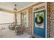Charming covered porch with rocking chairs, brick detailing, and a welcoming blue front door with wreath at 127 Marlow Dr, Woodstock, GA 30188