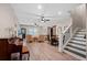Open-concept living room with hardwood floors, neutral walls, an upright piano, and a staircase at 127 Marlow Dr, Woodstock, GA 30188
