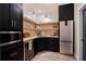 Modern pantry features black cabinetry, open shelving, quartz countertops, and stainless steel refrigerator at 127 Marlow Dr, Woodstock, GA 30188