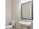 Bathroom features a pedestal sink, a framed mirror, and a toilet with decorative towels at 137 Centennial Ridge Dr, Acworth, GA 30102