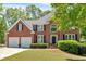 Traditional brick home featuring a two-car garage, manicured lawn, and a classic, symmetrical facade at 3921 Upland Way, Marietta, GA 30066