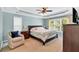 Spacious main bedroom featuring a ceiling fan, tray ceiling, and natural light from a large window at 3921 Upland Way, Marietta, GA 30066