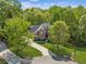 Aerial view of a two-story brick home surrounded by lush greenery and a winding driveway at 4750 Spring Wood Trce, Cumming, GA 30041