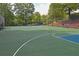 Well-maintained basketball court with ample space, surrounded by trees and fencing at 4750 Spring Wood Trce, Cumming, GA 30041