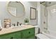 Charming bathroom with a unique green vanity, gold fixtures, and a shower-tub combination at 4750 Spring Wood Trce, Cumming, GA 30041