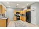 Functional kitchen with light wood cabinets, black appliances, and a basketball hoop on the door at 4750 Spring Wood Trce, Cumming, GA 30041