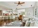 Bright living room flowing into the kitchen, featuring hardwood floors and an abundance of natural light at 4750 Spring Wood Trce, Cumming, GA 30041