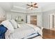 Cozy main bedroom with tray ceilings, dark floors, and a ceiling fan at 4750 Spring Wood Trce, Cumming, GA 30041