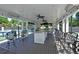 Outdoor kitchen area with bar seating, ceiling fans, and views of the tennis courts at 4750 Spring Wood Trce, Cumming, GA 30041