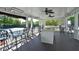 Relaxing outdoor kitchen area with ample seating, ceiling fans, and a granite countertop bar at 4750 Spring Wood Trce, Cumming, GA 30041