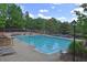 Large community pool with lounge chairs, blue and white pennant flags, and mature shade trees at 4750 Spring Wood Trce, Cumming, GA 30041