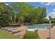 Outdoor community pool featuring tables, chairs, loungers and lush landscaping at 4750 Spring Wood Trce, Cumming, GA 30041