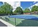 Fenced community tennis courts with blue and green surfaces, and ample seating at 4750 Spring Wood Trce, Cumming, GA 30041