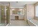 Bright bathroom featuring double vanity, soaking tub, and glass-enclosed shower at 550 Bayswater Way, Suwanee, GA 30024