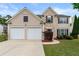 Charming two-story home with brick and siding, attached two-car garage and landscaped front yard at 550 Bayswater Way, Suwanee, GA 30024