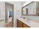 Bathroom featuring a white marble countertop, decorative mirror, and natural wood cabinets at 3883 Wakefield Hall Se Sq, Smyrna, GA 30080