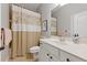 Bathroom with neutral tile flooring, white cabinetry, and a shower/tub combination with patterned curtain at 3883 Wakefield Hall Se Sq, Smyrna, GA 30080