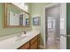 Bathroom featuring a white marble countertop, decorative mirror, and natural wood cabinets at 3883 Wakefield Hall Se Sq, Smyrna, GA 30080
