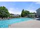 Community pool surrounded by mature trees, lounge chairs, and patio furniture at 3883 Wakefield Hall Se Sq, Smyrna, GA 30080