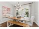 Dining room with rustic wood table, modern chandelier, and large windows overlooking the patio at 3883 Wakefield Hall Se Sq, Smyrna, GA 30080
