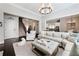 Bright living room with a large sectional, hardwood floors, and stairs creating a cozy gathering space at 3883 Wakefield Hall Se Sq, Smyrna, GA 30080