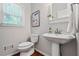 Bright bathroom features a pedestal sink, hardwood floors, and a window that provides natural light at 4047 Jordan Lake Dr, Marietta, GA 30062