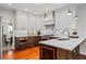 Modern kitchen featuring stainless steel appliances, white cabinets, marble backsplash and wood floors at 4047 Jordan Lake Dr, Marietta, GA 30062