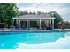 Tranquil pool with clear blue water, surrounded by a cabana, lounge chairs, and mature trees at 4047 Jordan Lake Dr, Marietta, GA 30062