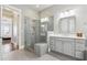 A walk-in shower with floor-to-ceiling tile, bench, and a seamless glass door and a vanity with a mirror at 413 Horizon Trl, Canton, GA 30114