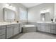 Bathroom showcasing dual vanities, white marble countertops, gray cabinetry, a soaking tub, and neutral tile flooring at 413 Horizon Trl, Canton, GA 30114