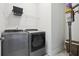 A laundry room with modern front-load washer and dryer, wire shelving, and a built-in vacuum system at 413 Horizon Trl, Canton, GA 30114