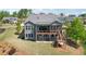 Rear exterior view showcasing the multi-level decks, screened porch, and landscaped backyard at 413 Horizon Trl, Canton, GA 30114