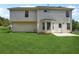 Back of house view from yard showing lawn, door and bay window of home with neutral siding at 10423 Commons Xing, Jonesboro, GA 30238
