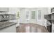 Well-lit kitchen featuring gray backsplash, granite countertops and hardwood flooring at 10423 Commons Xing, Jonesboro, GA 30238