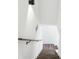 Modern staircase with wood treads and a simple handrail, illuminated by a sleek sconce for a minimalist design at 10423 Commons Xing, Jonesboro, GA 30238