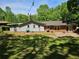 View of the backyard featuring the back of the house, a patio, and mature trees for shade at 1513 Wildwood Dr, Acworth, GA 30102