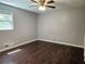 Spacious bedroom with dark hardwood floors, a window for natural light, and a ceiling fan at 1513 Wildwood Dr, Acworth, GA 30102